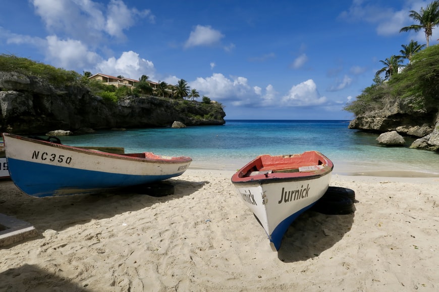 Barcos parados na areia da praia Lagun, para representar o seguro viagem para Curaçao - Foto: Sthephan Van de Schootbrugge via Unsplash
