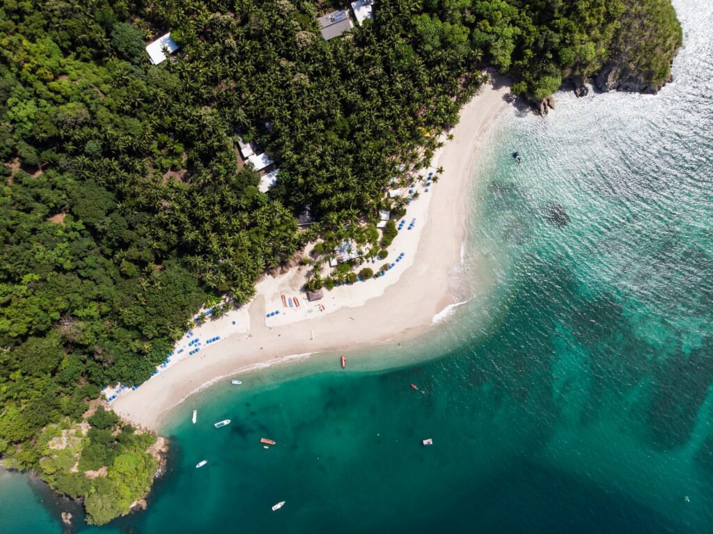 Vista de cima da praia La Isla Tortuga na Costa Rica com mar esverdeado e areias brancas para representar o seguro viagem para Costa Rica
