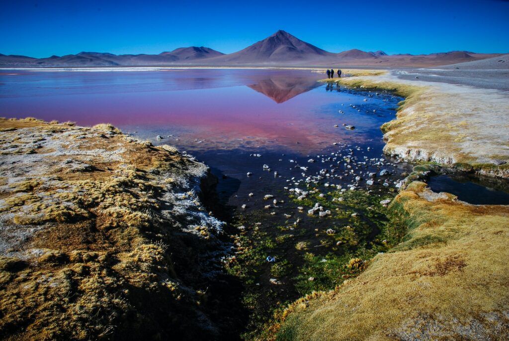 Altiplano andino com montanhas ao fundo e um lago passando ao meio. Seguro viagem Bolívia