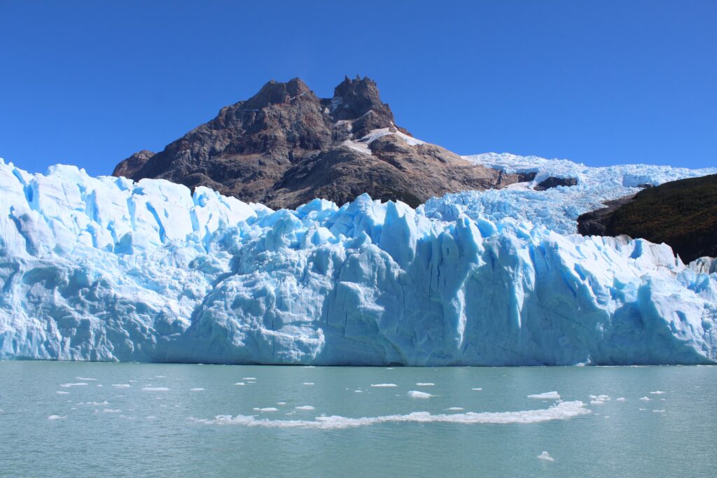 Montanhas de gelo subindo por dentre montanhas rochosas na região de El Calafate, cidade na Argentina para representar seguro viagem para Argentina