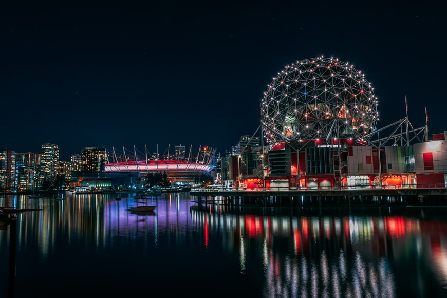 Lago e prédios em volta com muita iluminação em Science World, Vancouver, Canadá. Representa o seguro viagem Vancouver.
