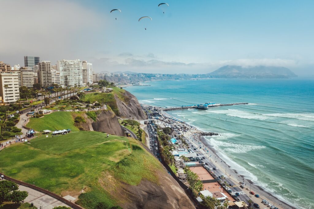 Montanhas que descem em direção a uma avenida que separa a praia da cidade em Lima no Peru para representar seguro viagem para Lima