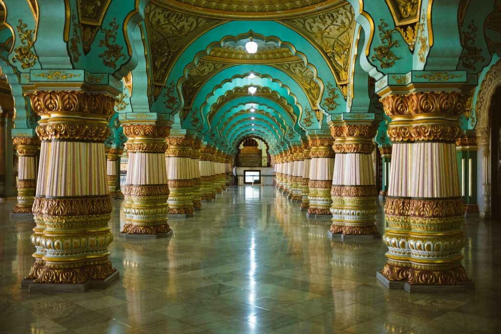 Parte interna do Palácio de Mysore na cidade de Mysuru na Índia em tons de azul, ouro e repleto de colunas que sustentem um teto arredondado, para representar o seguro viagem para Índia