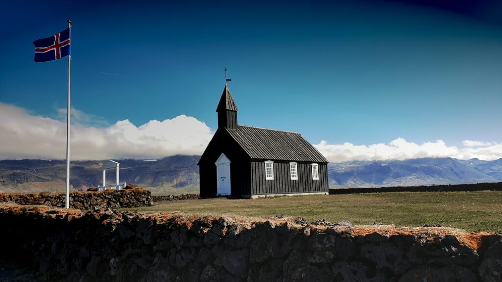 bandeira da Islândia perdo de uma igreja de madeira rustica- Representa seguro viagem Islândia