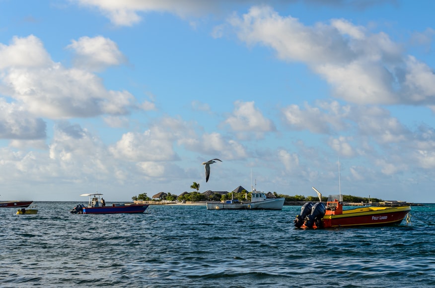 Mar azul e barcos navegando em Anguilla – representa o seguro viagem para Anguilla