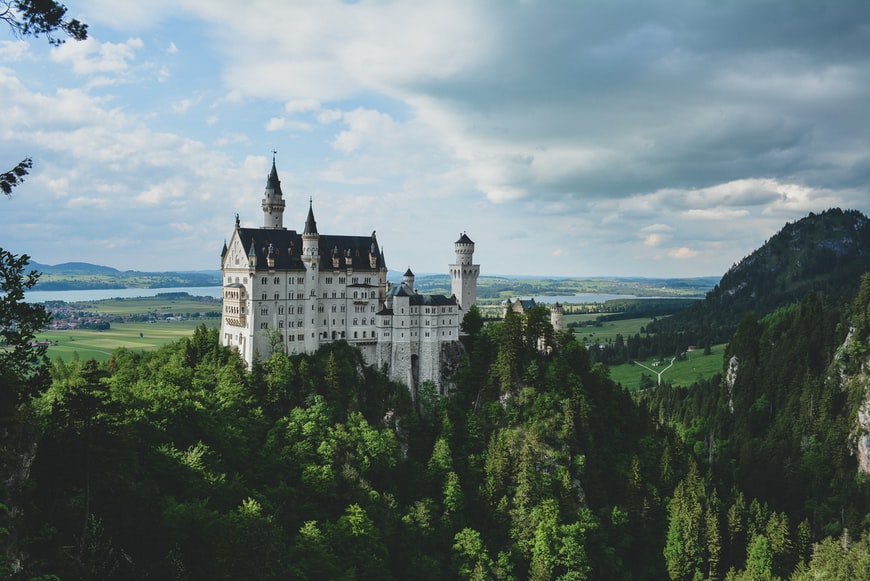 Castelo em Neuschwanstein, Schwangau, Alemanha em meio a floresta- Representa seguro viagem Alemanha.