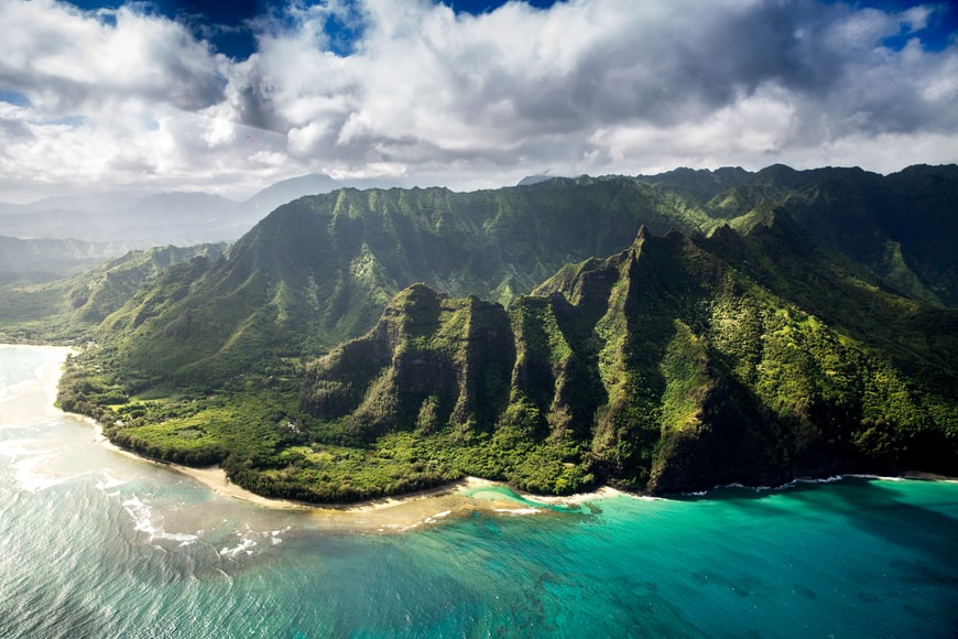 Condado de Kauai, Havaí, com montanhas e mar azul turquesa. – Foto: representa o seguro viagem para Havaí