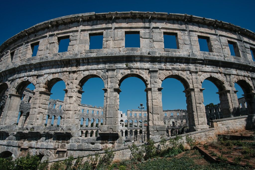 Uma construção arredondada em formato de arena com arquitetura romana, na cidade de Pula na cidade da Croácia, para representar o seguro viagem para Croácia