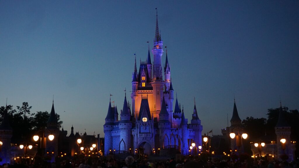 O famoso castelo Magic Kingdom na Disney aceso de noite para representar o melhor seguro viagem para os Estados Unidos