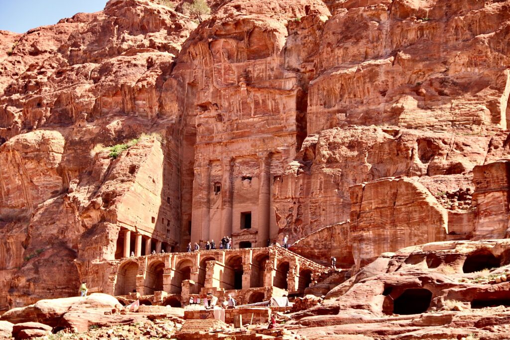 Uma enorme cidade construída em uma rocha em Petra na Jordânia, colunas e escadarias, construção em ruínas, tudo feito de uma rocha em tom de laranja