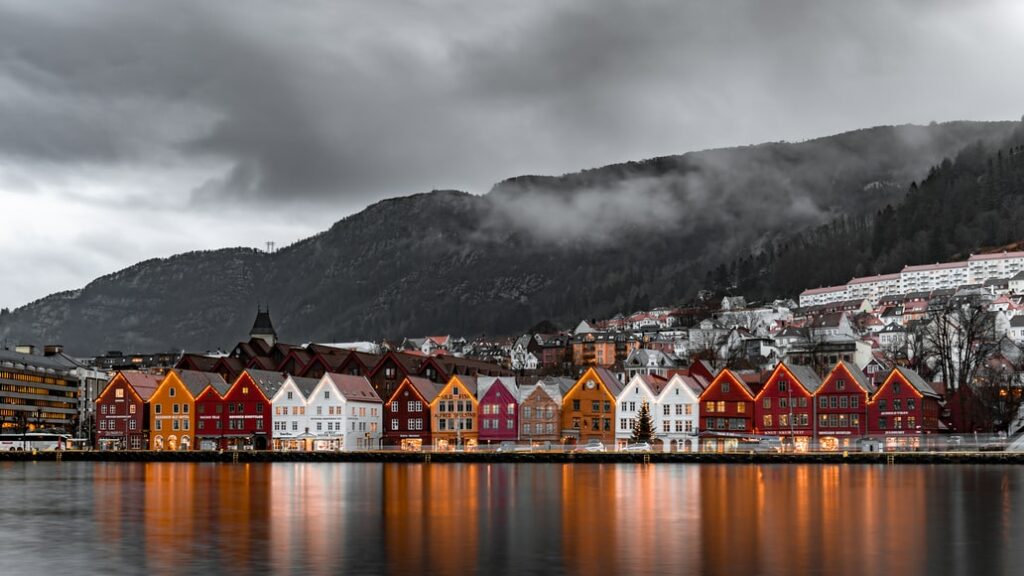 Casas de madeira em meio a montanhas em Bryggen, Bergen, Noruega - Representa seguro viagem Noruega.

