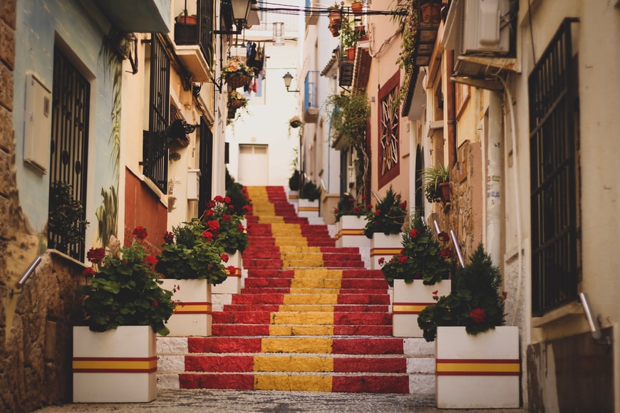 Escadaria com cores da bandeira da Espanha Cidade Velha, Calp, Espanha - Representa o seguro viagem Espanha