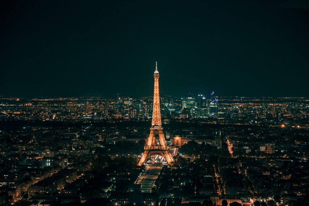 Torre Eiffel na França acessa de noite para representar o melhor seguro viagem para Europa