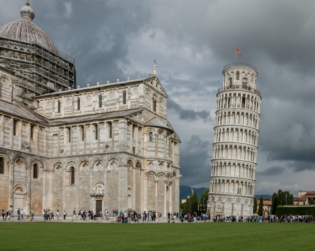 Famosa Torre de Pisa na Itália construção antiga levemente caída para um dos lados dando a sensação de estar caindo, para representar o seguro viagem para Itália