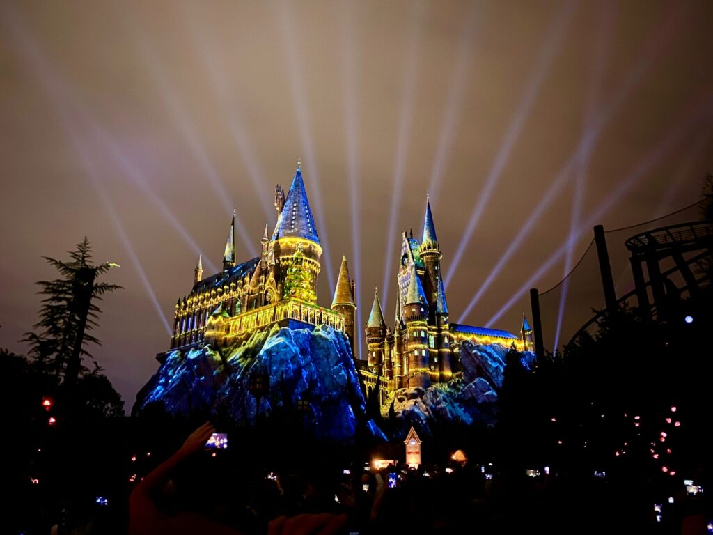 Um castelo de Hogwarts por entre as montanhas, inteiro acesso em cores de amarelo e azul no parque do Harry Potter em Orlando para representar o seguro viagem para Orlando