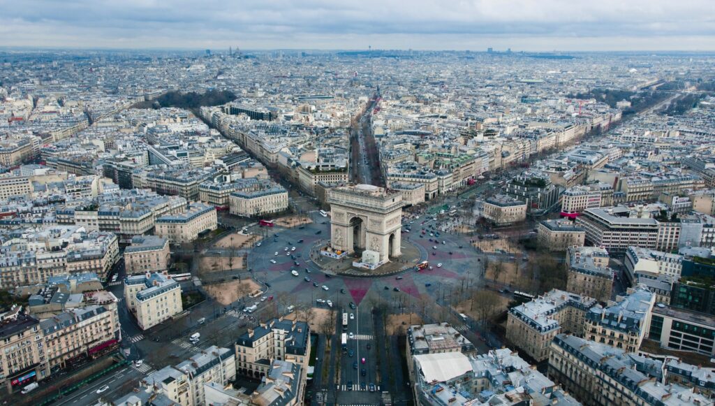 Vista de cima da área central de Paris na França mostrando o Arco do Triunfo e todas as ruas, casas e prédios ao redor para representar o seguro viagem para França