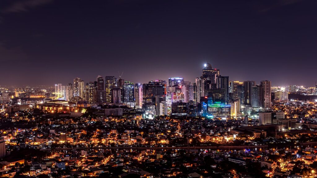 Malina, capital das Filipinas de noite com todos os prédios e casas com as luzes acesas para representar o seguro viagem para Filipinas