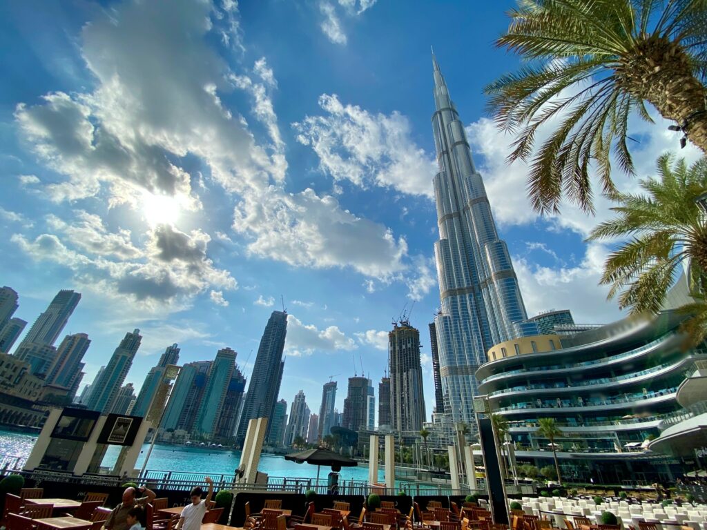 Região luxuosa de Dubai com prédios espelhados, restaurantes e em destaque o Burj Khalifa, o maior arranha-céu do mundo, para representar o seguro viagem para os Emirados Árabes