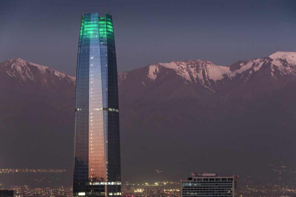 Gran Torre Santiago, um arranha-céu com 200 metros de altura e, ao fundo, as cordilheiras para representar seguro viagem para Santiago