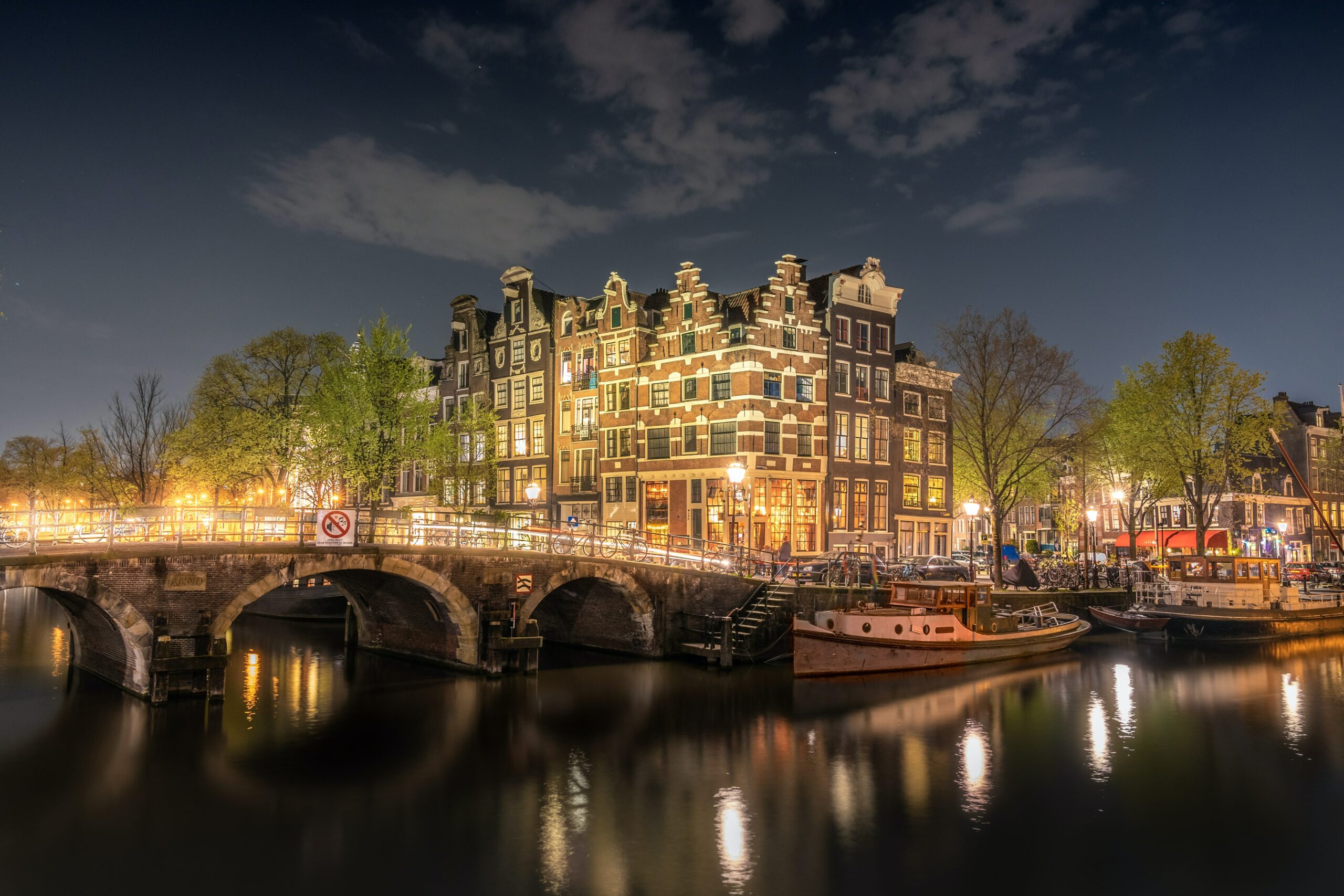 ponte de pedra Papiermolensluis entre os canais de Amsterdam a noite.
