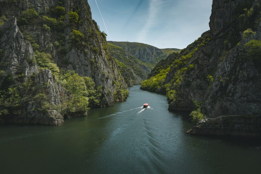 Canyon Matka em Skopje na Macedônia, um enorme lago com um único barco andando por entre esse pedaço de água que corta duas enormes montanhas