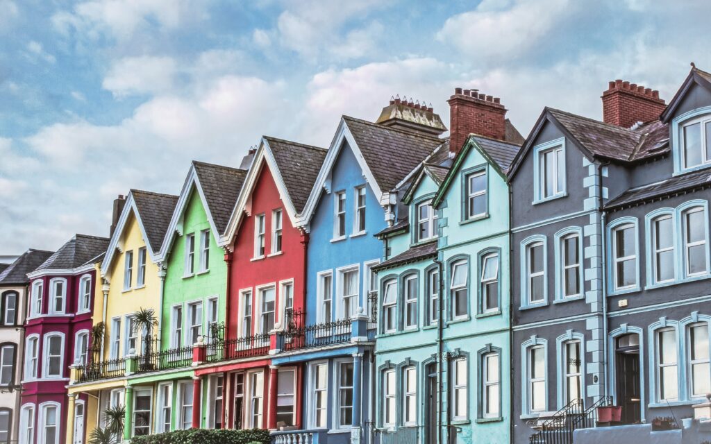 Casas coloridas ao longo da rua à beira-mar em Whitehead. Representa seguro viagem para Irlanda do Norte.