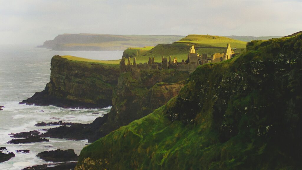 Vista do Castelo de Dunluce, Irlanda do Norte  no meio da montanha em frente ao mar - Representa seguro viagem para Irlanda do Norte