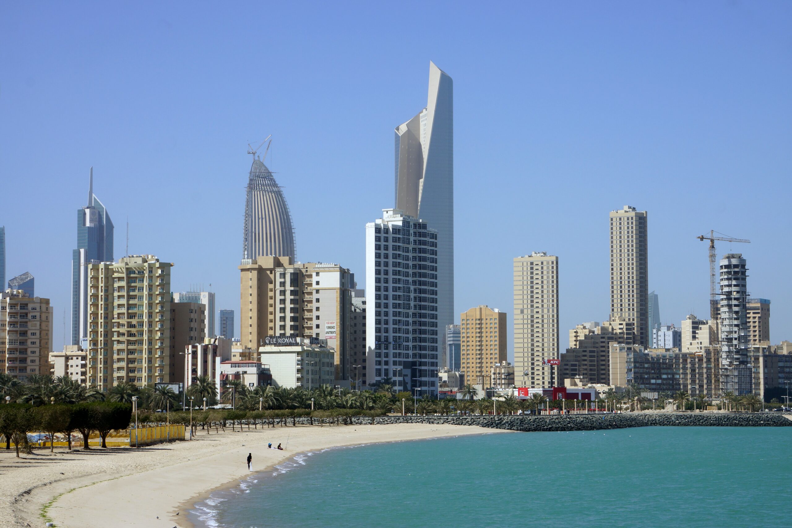 Vista da Cidade Kuwait, em Kuwait com prédios e mar em volta.