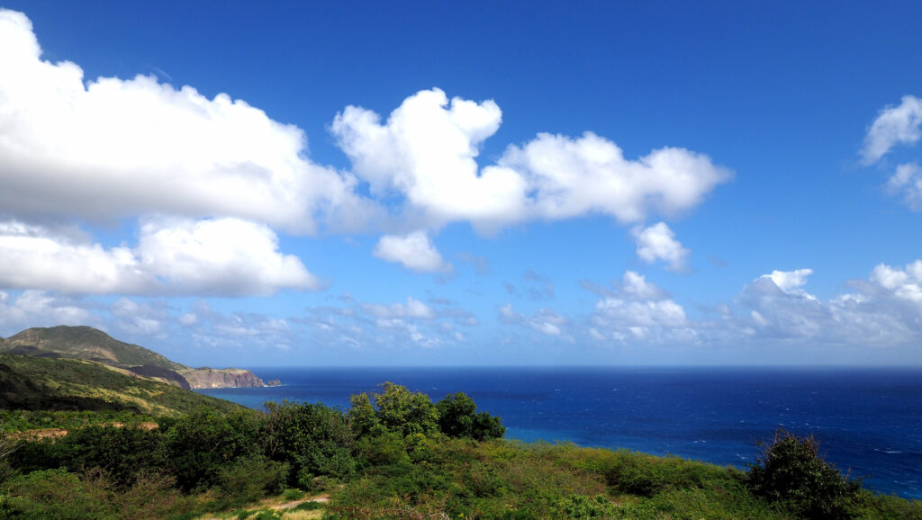 Paisagem de Montserrat, o mar azul escuro, montanhas e muita vegetação ao redor