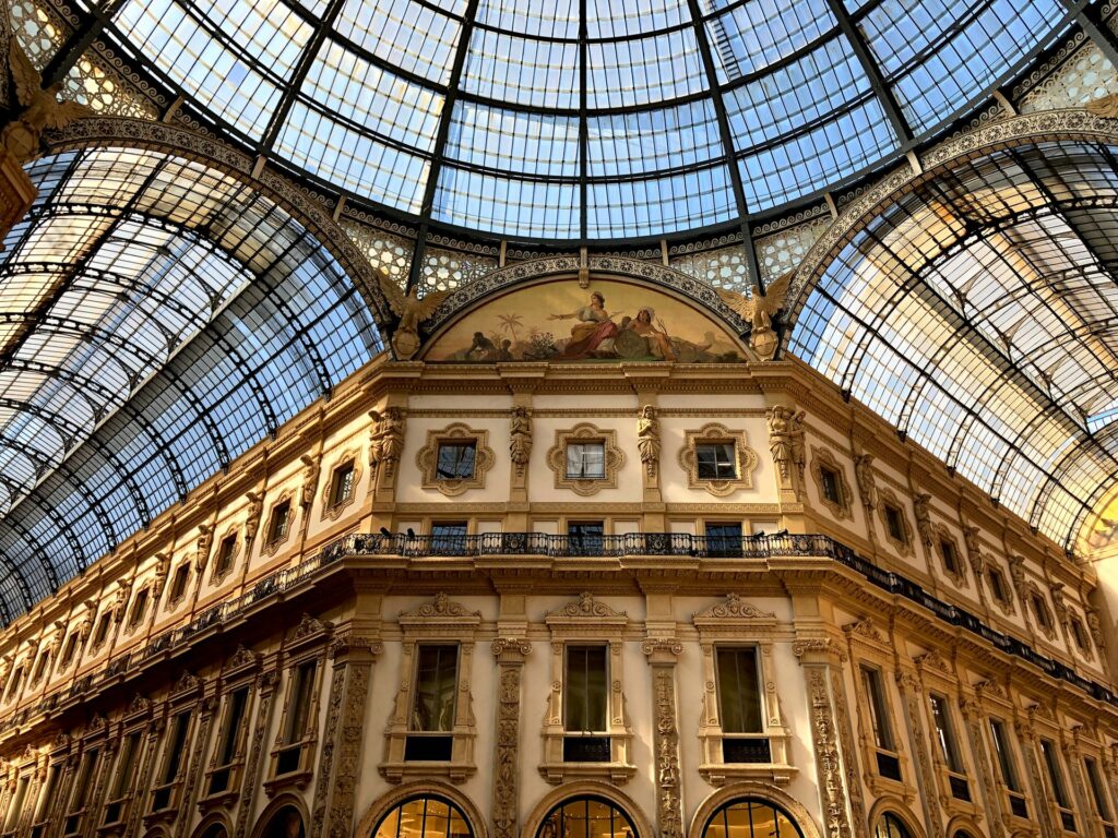Galeria Vittorio Emanuele II, uma enorme galeria com teto arredondado de vidro, com desenhos e arquitetura renascentista, para representar o seguro viagem para Milão