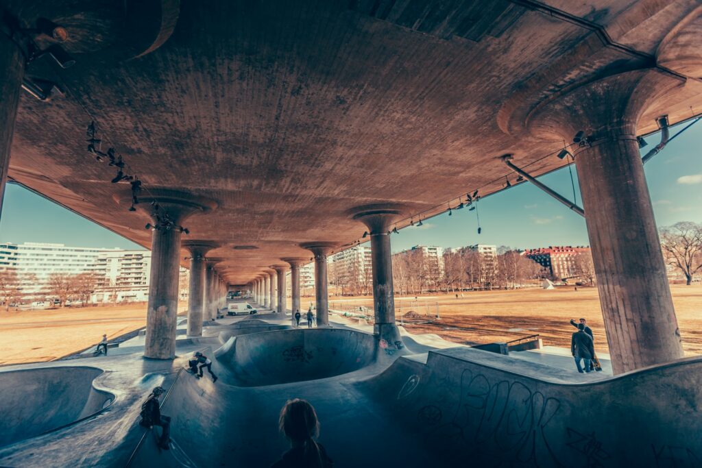 Uma ampla pista de skate com diversas elevações e uma enorme cobertura sustentado por pilares, dando a impressão que um enorme ponte passa por cima da longa pista de skate Rålis em Estocolmo, para representar o seguro viagem para Estocolmo
