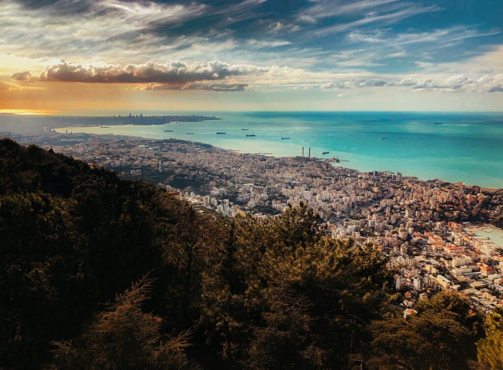Praia de Jounieh na Província do Monte Líbano, vista de cima, é possível ver a cidade litorânea se estendendo por toda a orla, mar de águas claras e alguns barcos navegando, para representar o seguro viagem para o Líbano