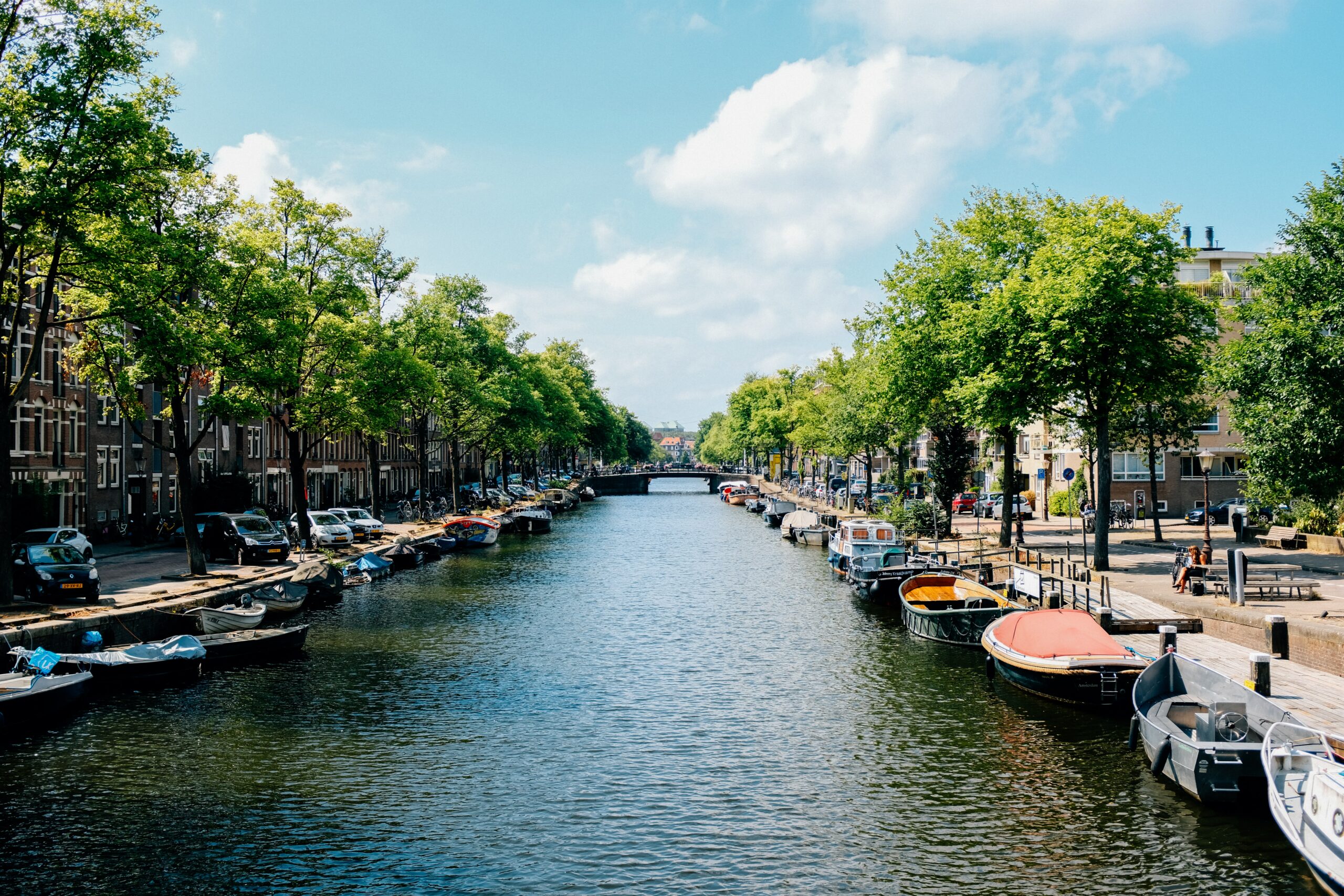 Canal de rio com barcos na margem em Pays-Bas, Amsterdã, Holanda -Representa seguro viagem para Amsterdam.