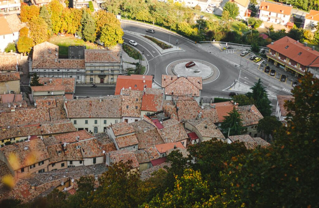 Província de Forlì Cesena em San Marino, um lugar simples com casas de telhados claros e antigas, muitas árvores e vegetação ao redor, poucos carros nas ruas, para representar o seguro viagem para San Marino