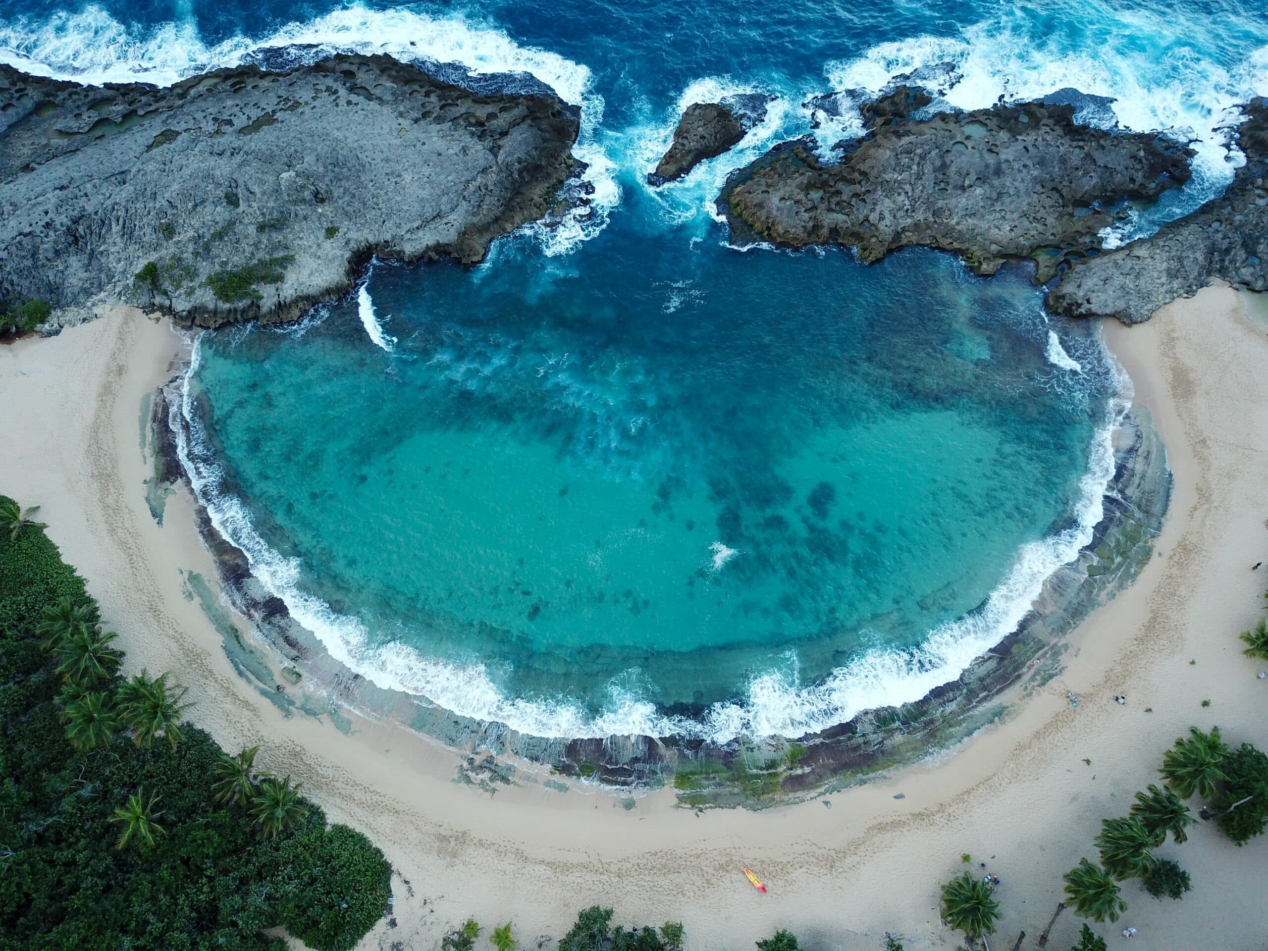 Vista de cima da Praia Mar Chiquita,  Porto Rico, com mar azul turquesa e areias brancas. - Representa seguro viagem para Porto Rico.