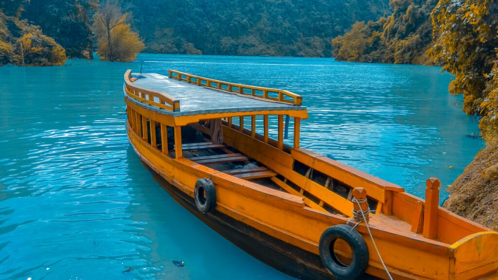 Barco de madeira em Rangamati, Bangladesh em volta de um mar azul - Representa seguro viagem para Bangladesh.