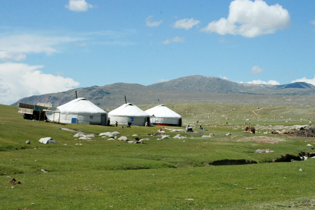 Vilarejo Yurt, em Mongólia com cabanas brancas em meio a montanhas - Representa seguro viagem para Mongólia.