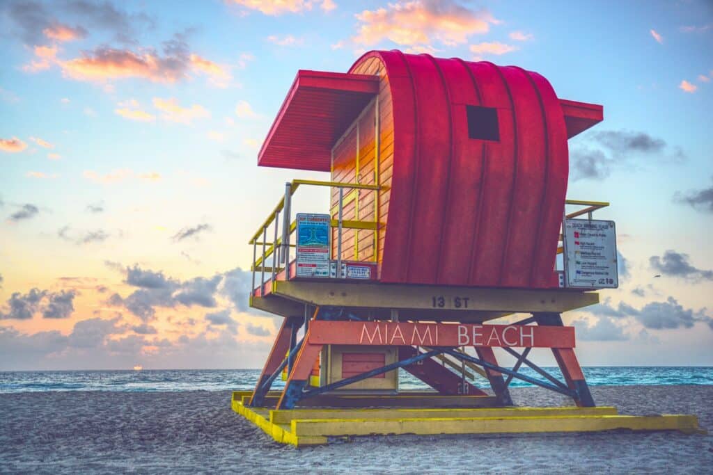 posto vermelho e amarelo de madeira na praia de South Beach, Miami Beach com céu azul e nuvens ao entardecer