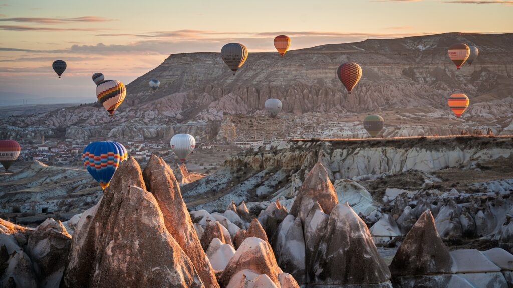 vista de balões coloridos na Capadócia, Turquia, com estruturas de pedra abaixo imponentes