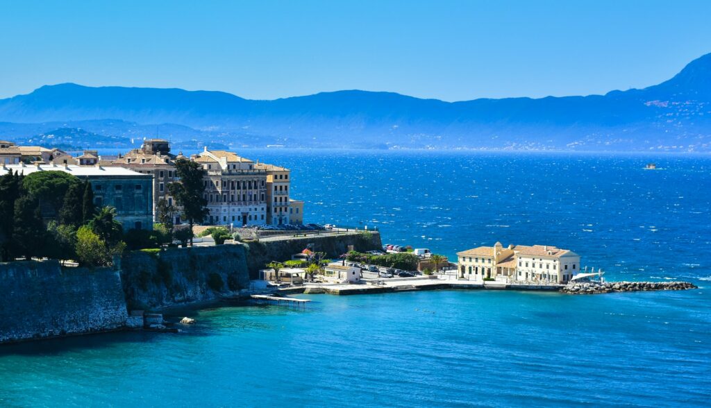 vida da cidade de Corfu, em meio ao mar bem azul, com arquitetura clássica grega