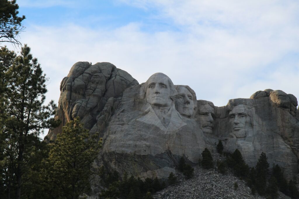 Rocha esculpida com os  rostos dos exs presidentes dos Estados Unidos como George Washington, Thomas Jefferson, Theodore Roosevelt e Abraham Lincoln. 

