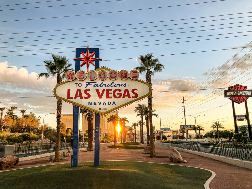 Placa dizendo "Welcome to fabulous Las Vegas, Nevada" para ilustrar o post sobre chip internacional para Las Vegas. A famosa rua Strip está iluminada pelo por do sol. - Foto: Sung Shin via Unsplash