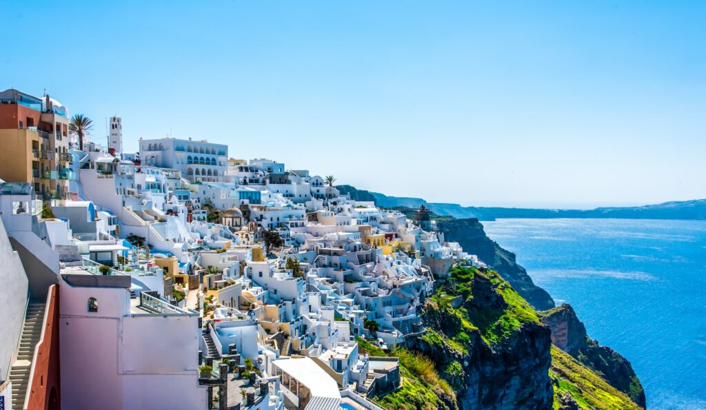 vista da cidade com casinhas brancas à beira mar em Santorini, que pode ser visitada com um chip internacional Grécia