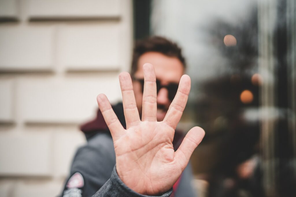 Um homem com a mão aberta mostrando os cinco dedos