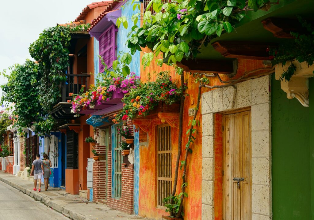 Várias casas coloridas com flores e plantas como decoração durante o dia, ilustrando post chip internacional para Cartagena.