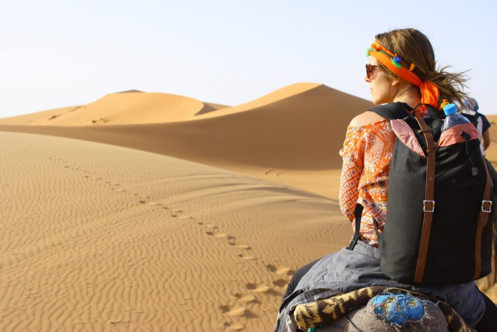 mulher cavalgando em meio ao deserto do Saara