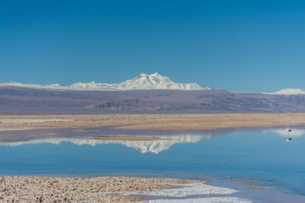 Vista de dia das montanhas de Salar de Atacama, Chile, com um lago a frente e ao fundo as montanhas. Representa chip internacional para o Atacama.
