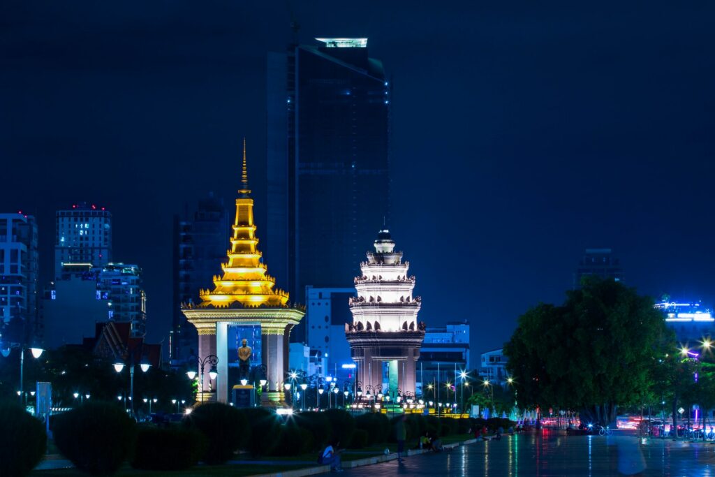 Foto de edifício de concreto branco e dourado durante à noite para representar o chip internacional para o Camboja. 