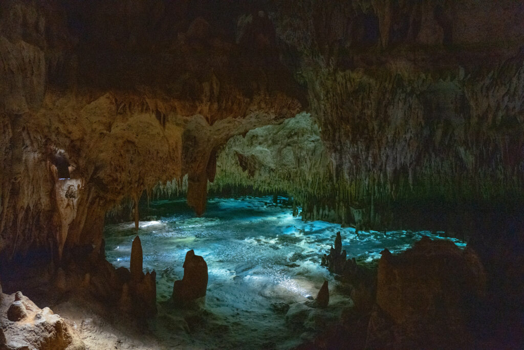 Caverna com várias formações rochosas pontiagudas no teto e no solo, e com um lago no meio. Foto para ilustrar post sobre chip internacional para Ilhas Cayman.