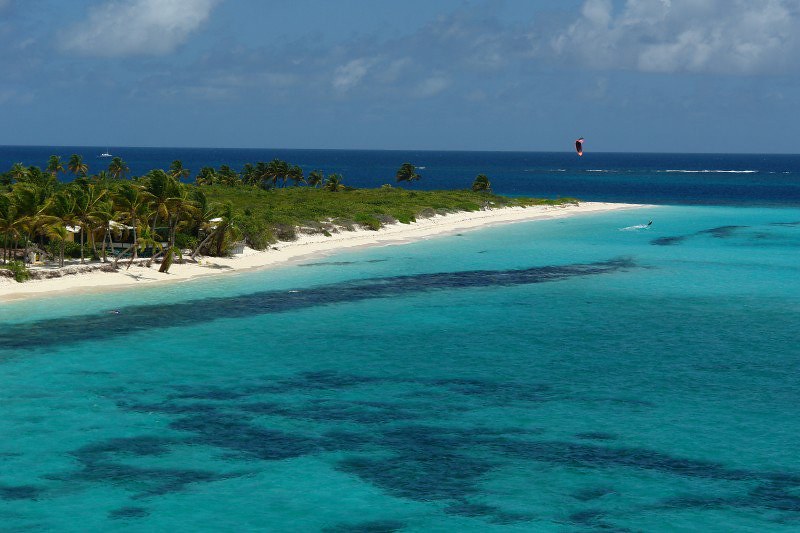 Vista da Anguilla, mar claro, lado esquerdo com areia e árvores